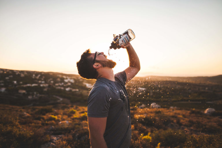 man drinks water in fall