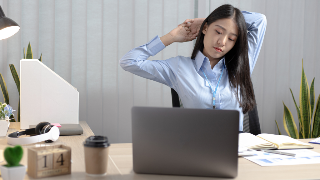 woman stretching at her desk using kaizo health's top stretches recommended by a chiropractor