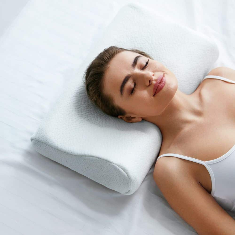 Woman sleeping in proper position with pillow for neck pain