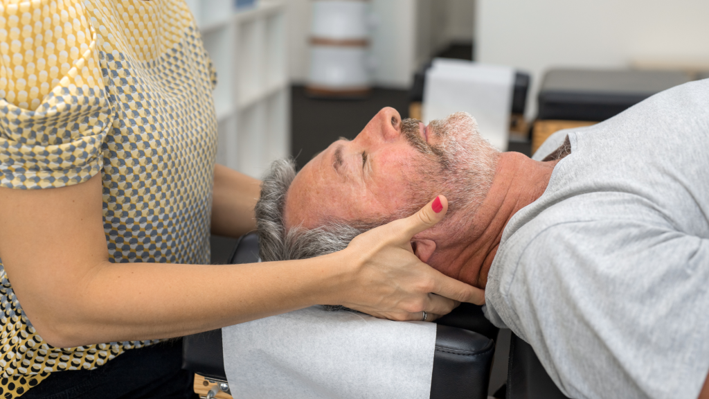 man getting a neck adjustment at chiropractor using his health insurance plan