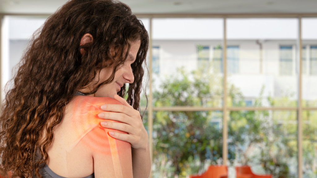 woman holding right shoulder because of labral tear pain and going to see chiropractor at kaizo health for exercises