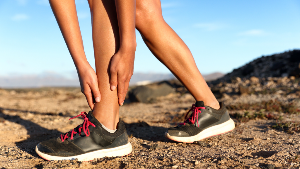 person holding left ankle after twisting it from hiking