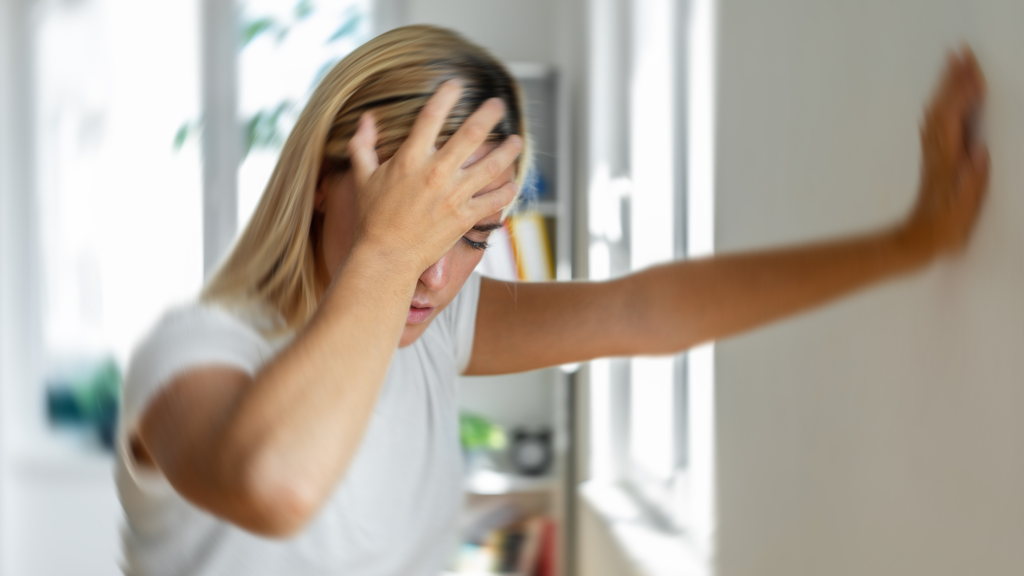 woman holding head because of vertigo